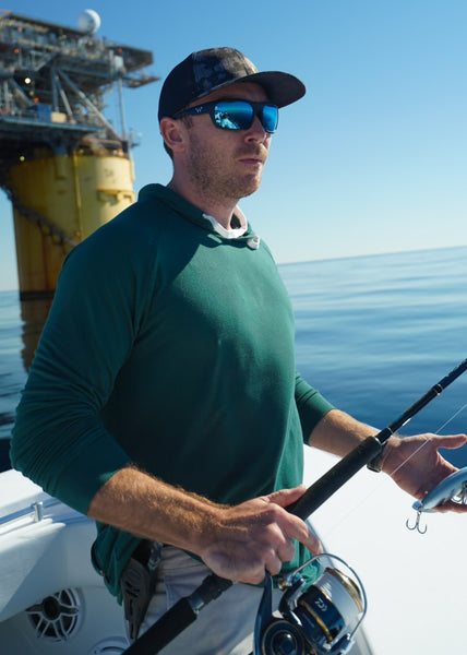 Fisherman wearing the Cruiser Midweight Hoodie in Green.